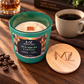 Bourbon Coffee 12 oz soy candle in a matte green glass jar with a crackling wood wick and engraved wood lid